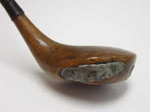 マグレガーの木製ドライバー。館蔵目録が1900〜1919年の範囲に置く、マグレガーの木製ドライバー。添付札の年代表示は1900年。実物写真を時代のアイコンとして使い、単年の発売モデルや王者の使用品とは断定しない。